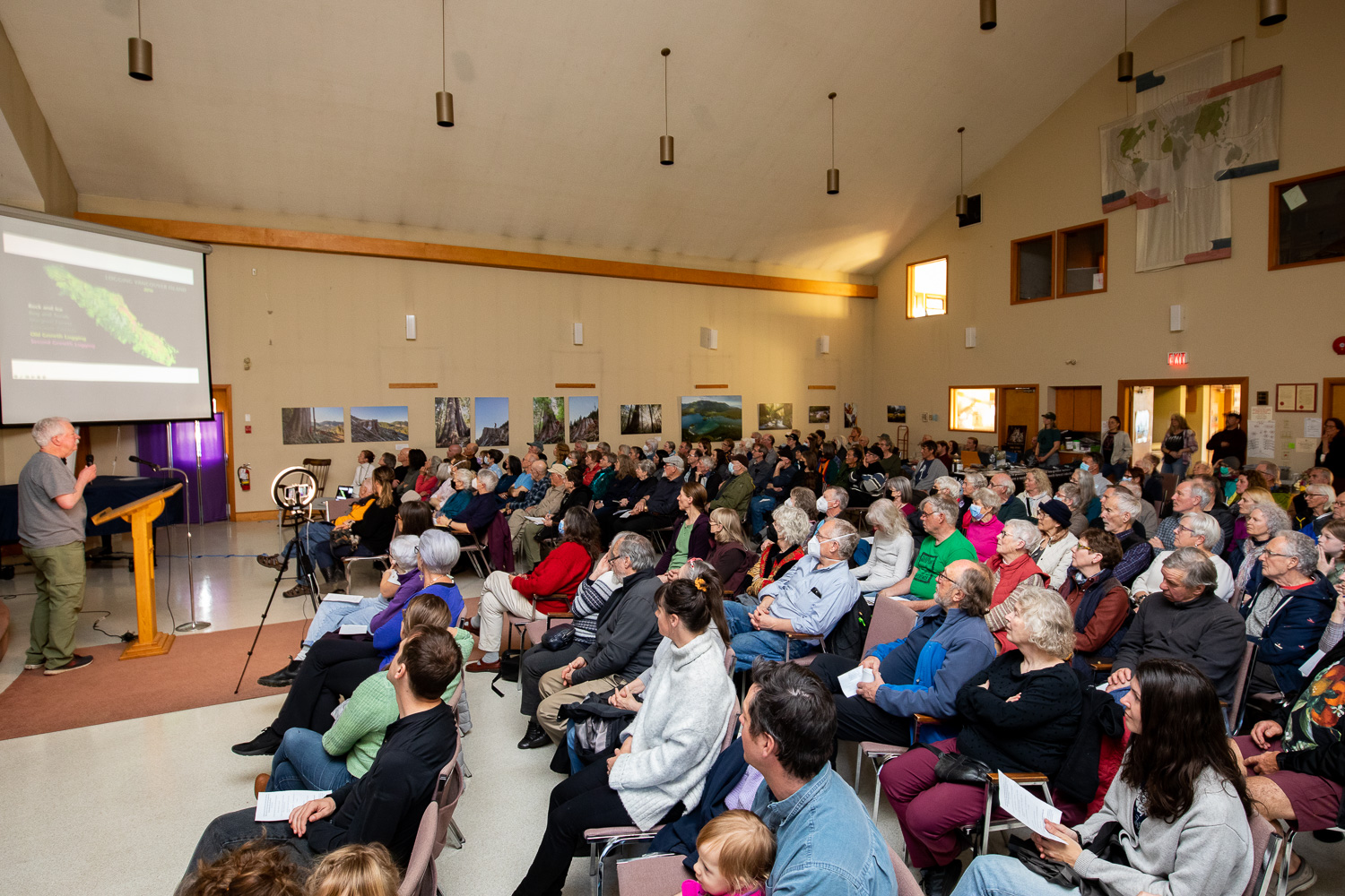 About 200 people listening intently as renowned forest ecologist Andy MacKinnon presents about old-growth forests vs. second-growth tree plantations